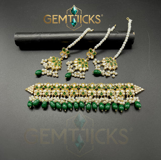 Jewelry set with green and gold elements on a dark background, featuring the Gemtiques brand.