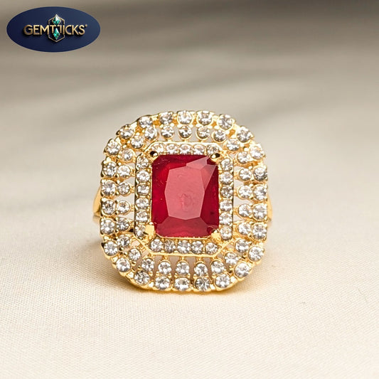 Gold ring with a red gemstone and clear stones on a beige background, featuring Gemticks logo.