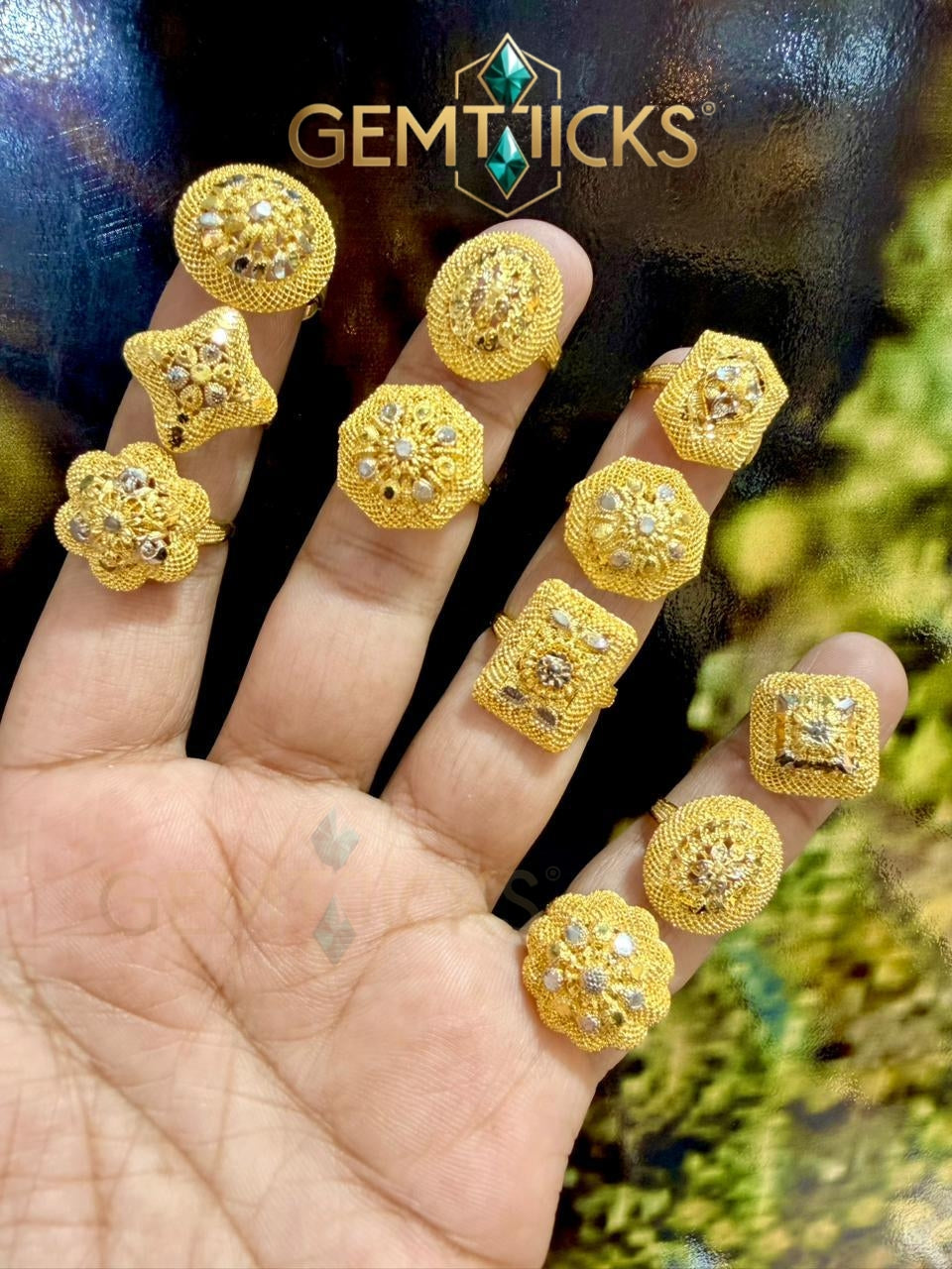 Gold earrings displayed on a hand with Gemticks branding.