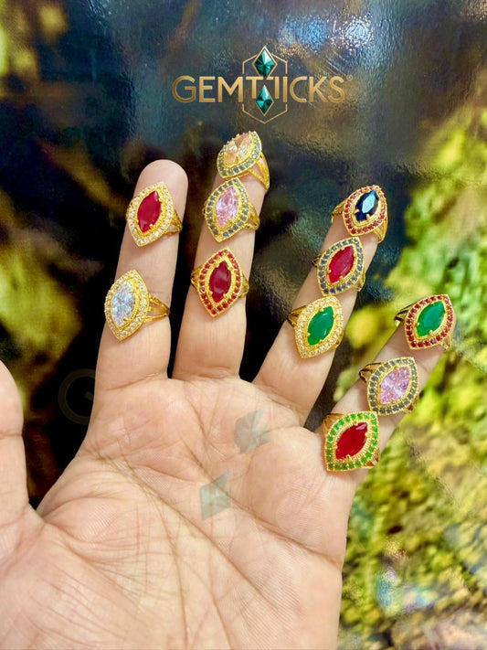 Gold rings with colorful gemstones on a hand, branded 'GEMTICKS'.
