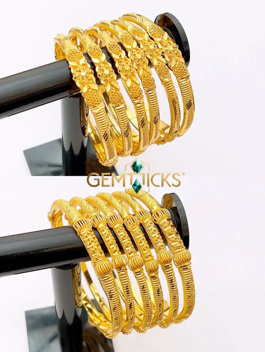 Stack of six premium 22K gold plated bangles with intricate textured filigree work on a display stand.