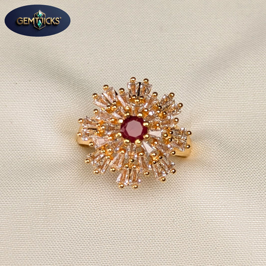 Gold and red gemstone brooch on a beige fabric background with Gemwicks logo.