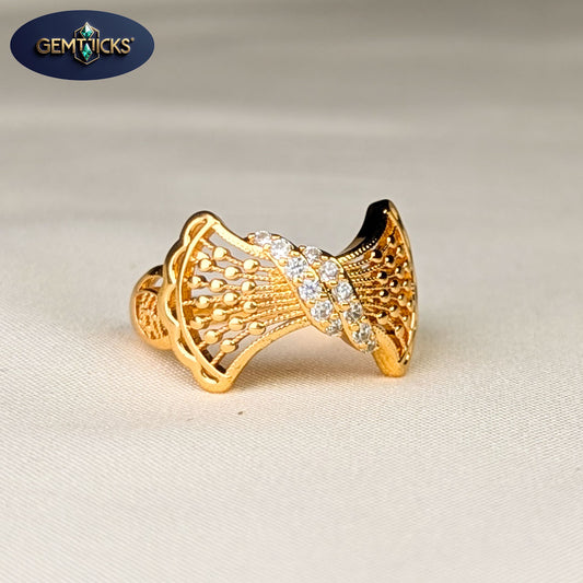 Gold ring with intricate design on a beige background, featuring Gemticks logo.