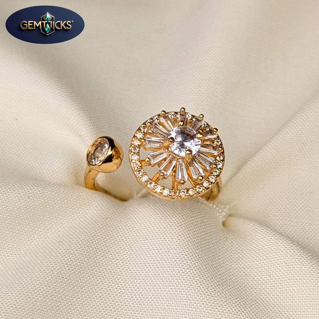 Two gold rings with gemstones on a beige fabric background, featuring the Gemticks brand.